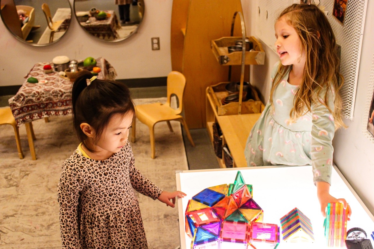 Two children by table chatting and playing