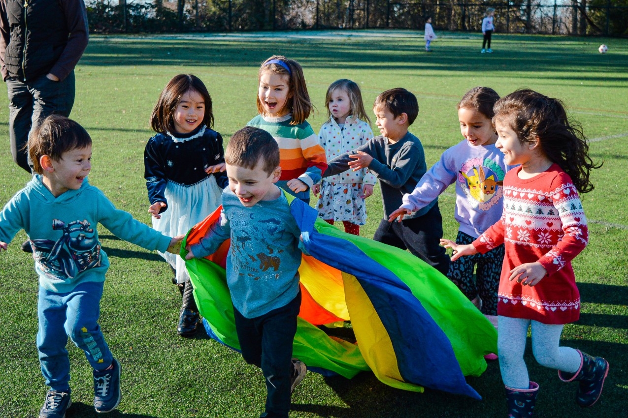Children on soccer field running around smiling