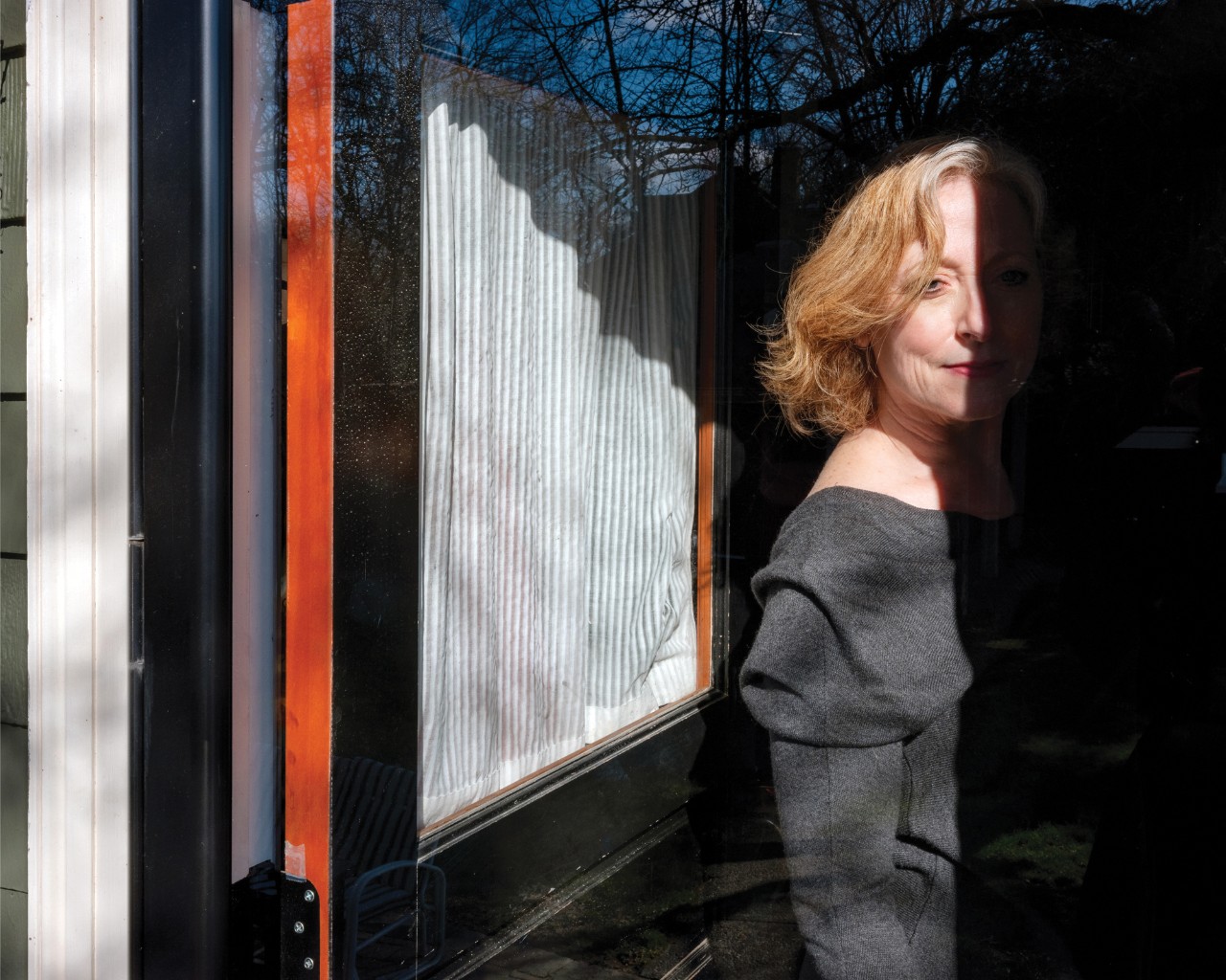 Figure 4. "Linda, Watertown, Massachusetts, 2020." Linda is half hidden in shadows as she opens her door for a look outside.