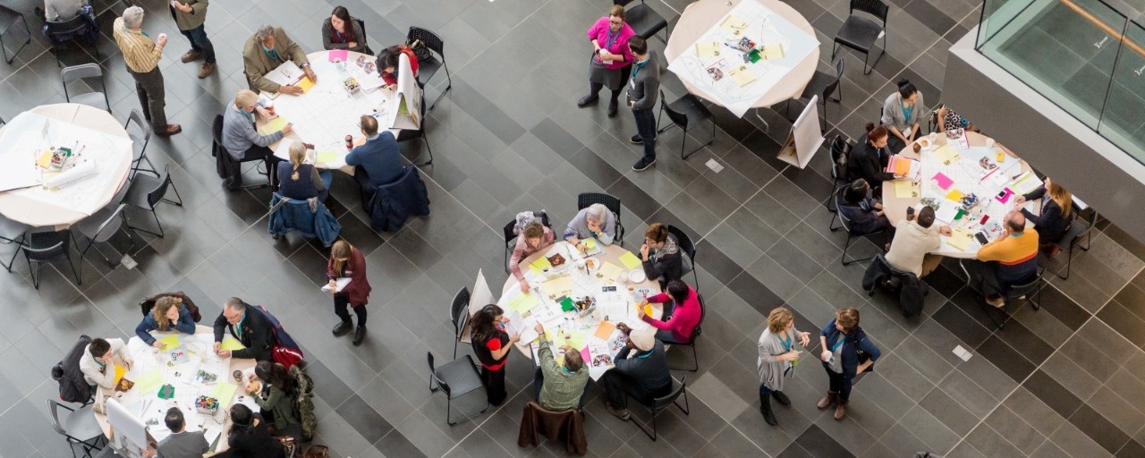 Bird's eye view of participants sitting at round tables during a dialogue