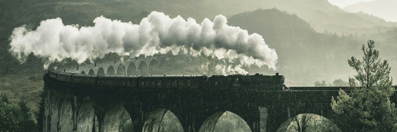 A train going over a bridge with smoke