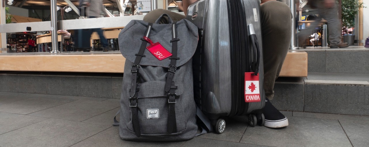 SFU backpack alongside luggage at the airport