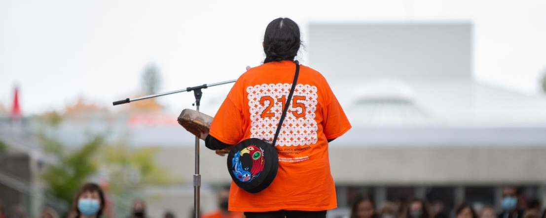 Elder Syexwaliya drumming at an Orange Shirt Day Ceremony
