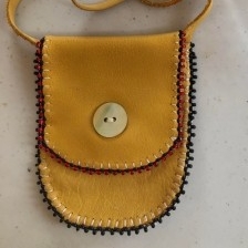 Tan coloured medicine pouch with a beaded edge and button