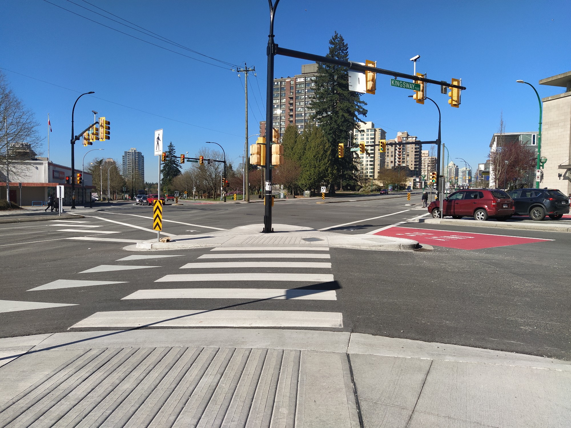 A three-way crosswalk with a pedestrian landing in the middle of the road.