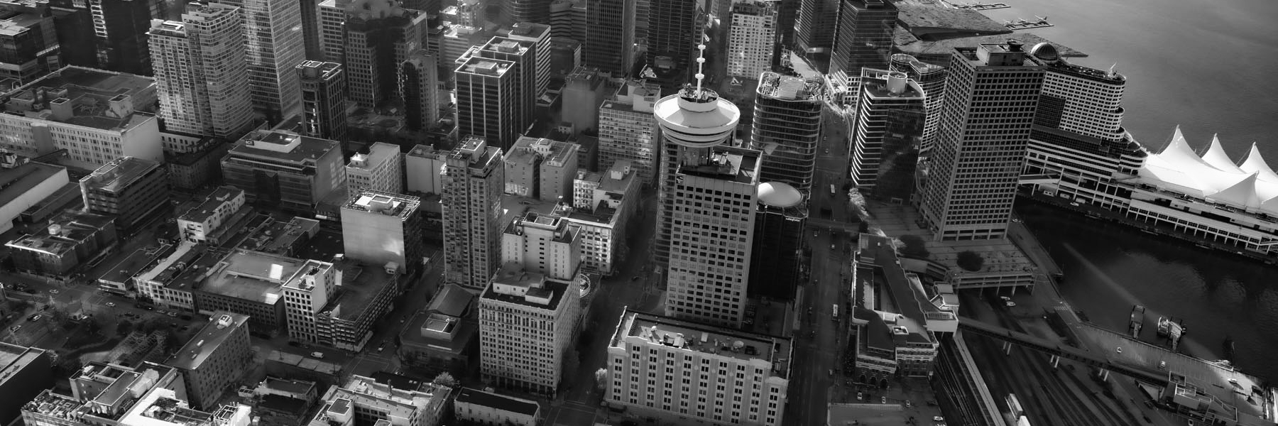 A black and white, aeriel image of downtown Vancouver, including Harbour Centre and Canada Place