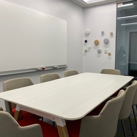 Enclosed study space with a table, chairs, and whiteboard