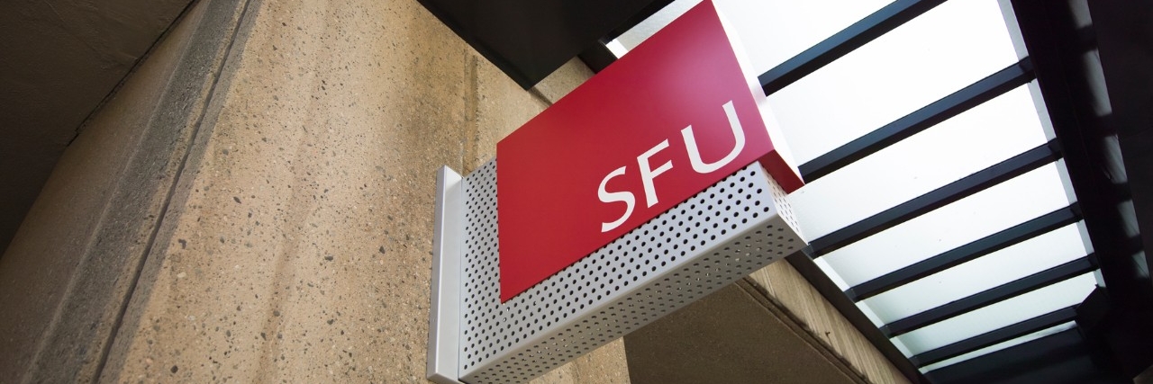 Red SFU sign outside of main entrance to Harbour Centre on Hastings Street