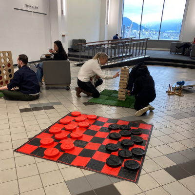 Four people playing Giant Jenga and Giant Connect 4 in the Games Lounge in the Harbour Centre Concourse