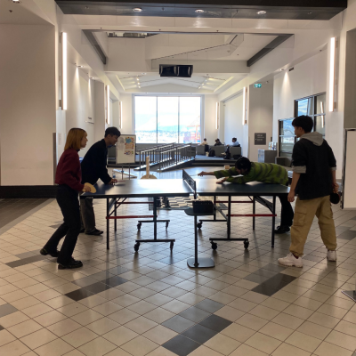 Four students playing ping pong during Ping Pong Fridays in the Harbour Centre Concourse