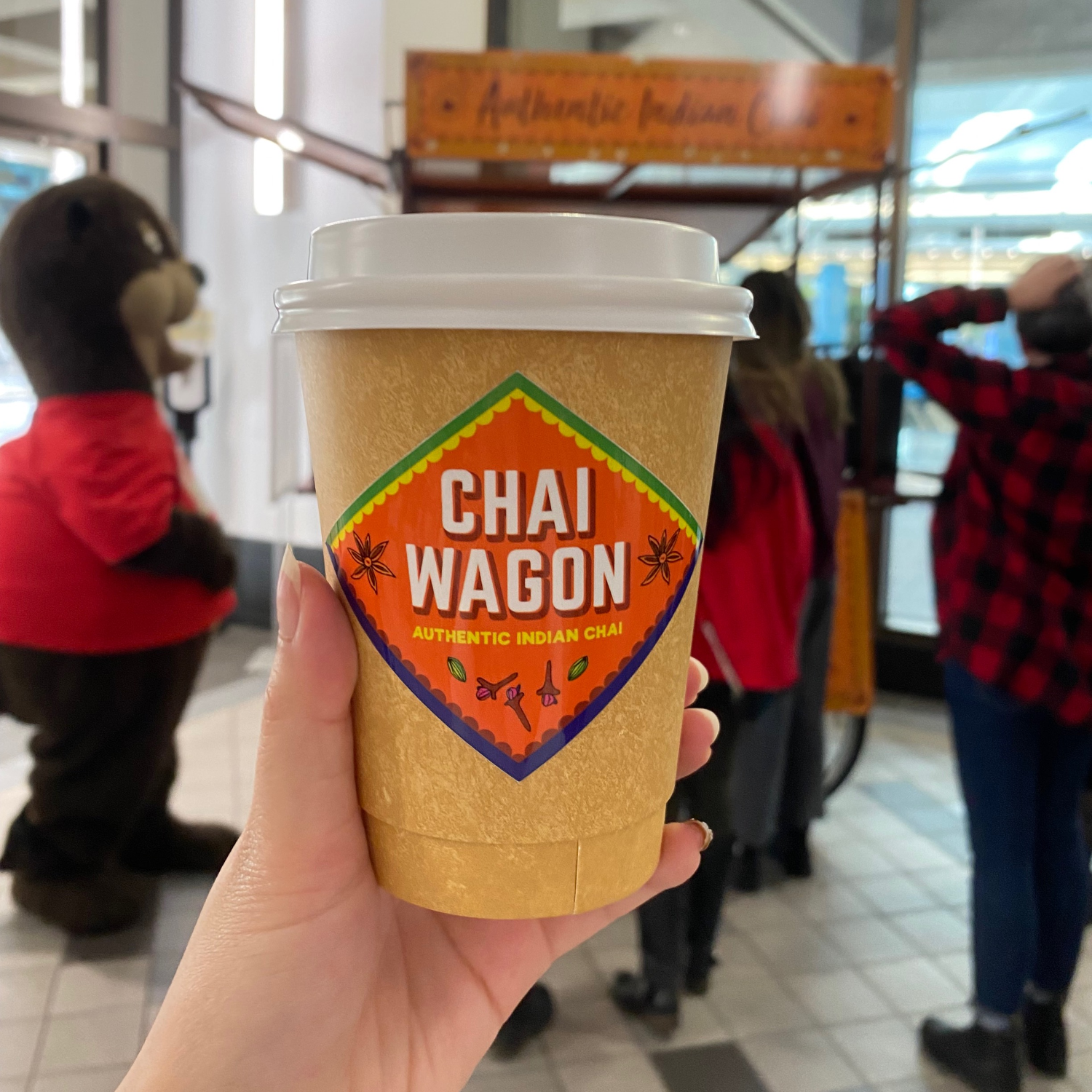 A hand holding a cup of chai tea latte from the Chai Wagon at the 2022 Fall Social