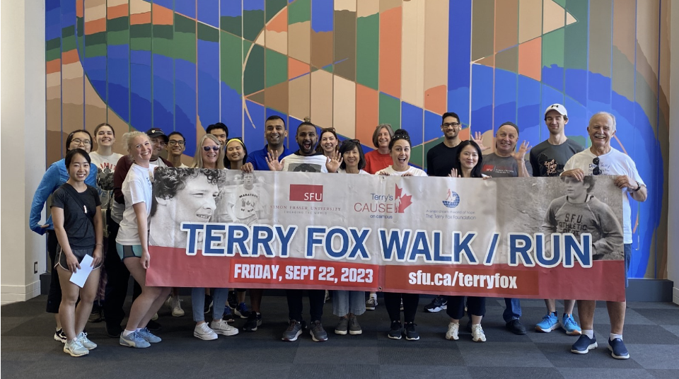 Participants take a group photo with the Terry Fox banner in the Teck Gallery at Harbour Centre before the run/walk