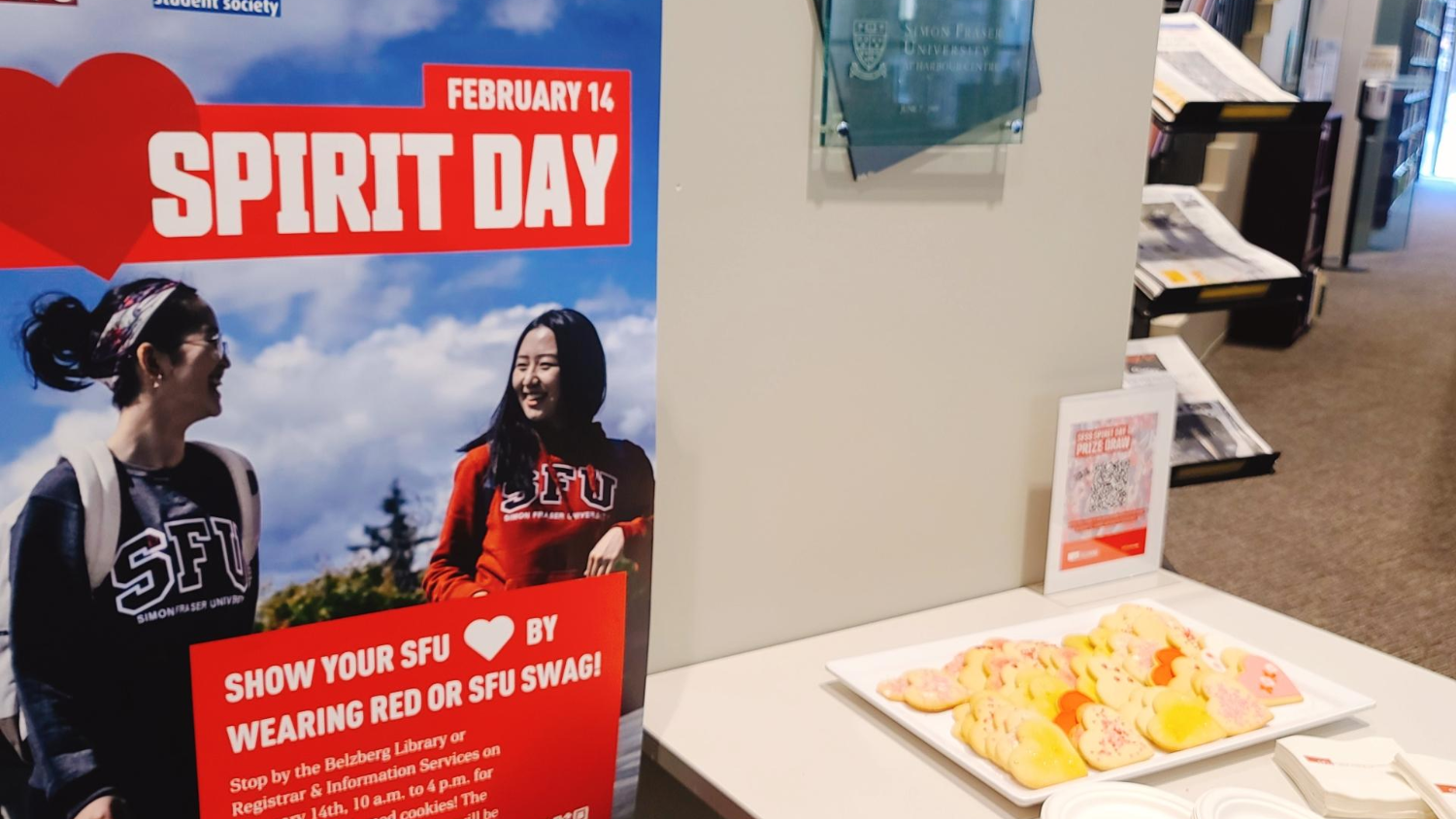 SFU Spirit Day poster and heart-shaped cookies set up on a table in the Belzberg Library