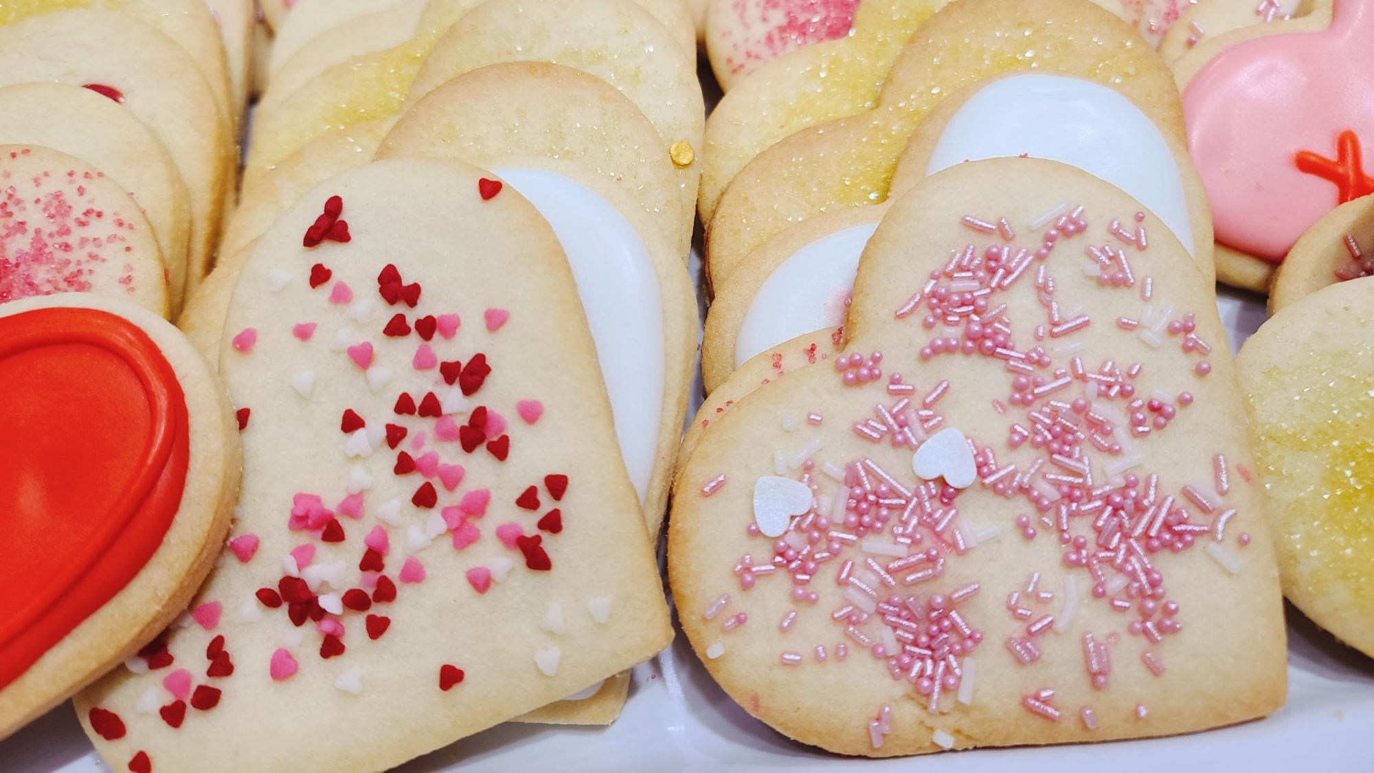 Heart-shaped cookies decorated with various sprinkles and icing