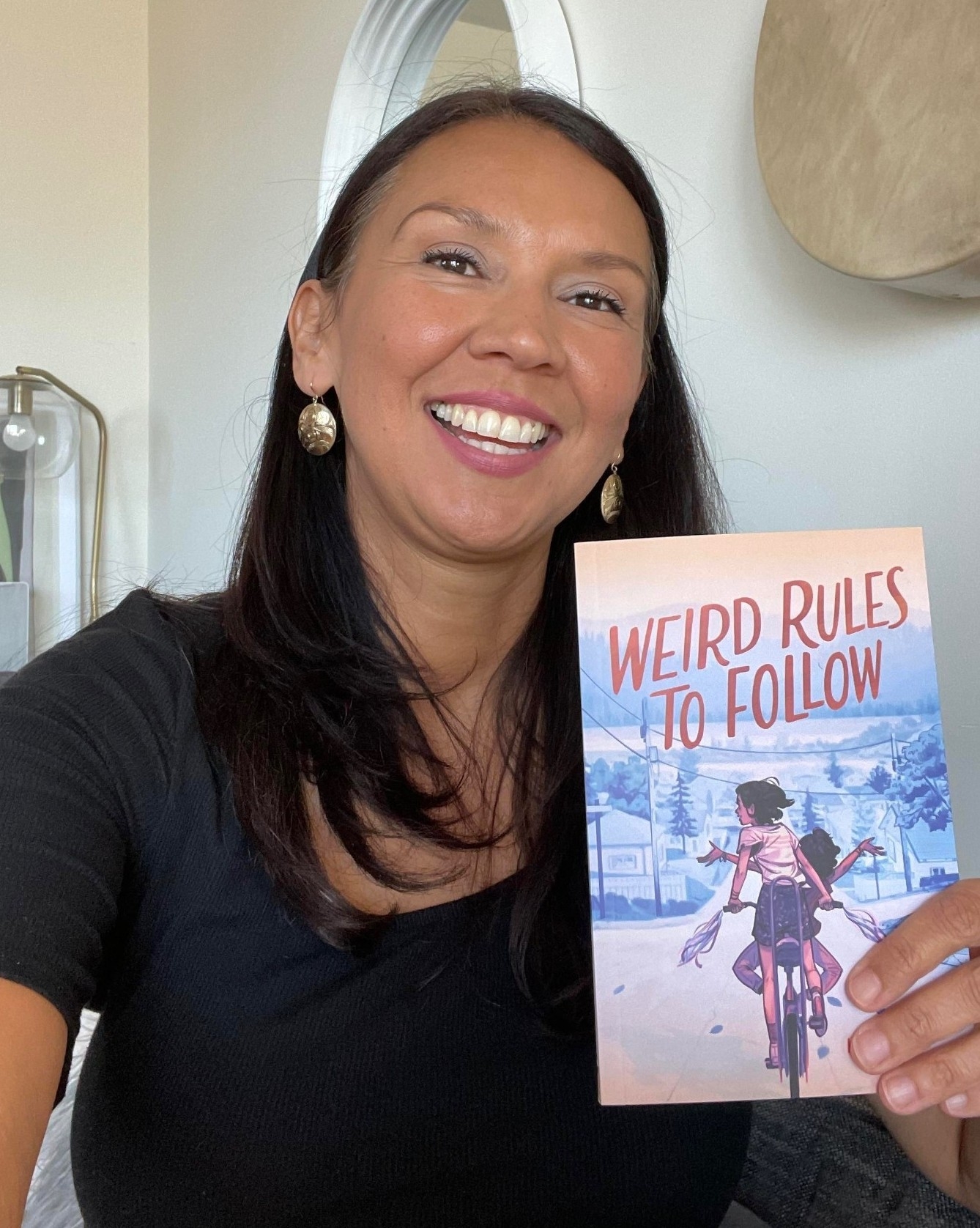 Kim Spencer holding her book "Weird Rules to Follow"