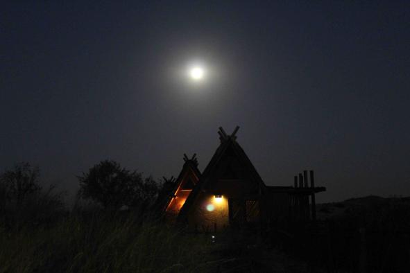 Chalets at !Xaus Lodge illuminated by the full moon. At night, the lodge receive