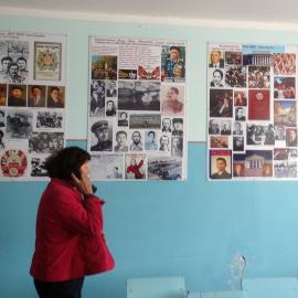 Asipa Adumbaevaat at Bolot’s school museum at Kara-Suu, with posters made by Kub