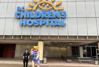 Student standing in front of BC Children's Hospital building and sign