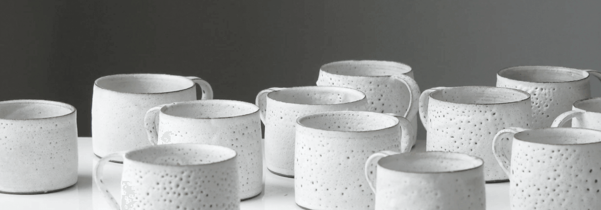 a collection of white mugs lined up.
