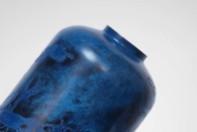A tilted shot of a rounded deep blue vase.