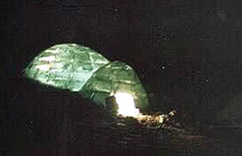 Igloo lit up with kudlik (oil lamp)
