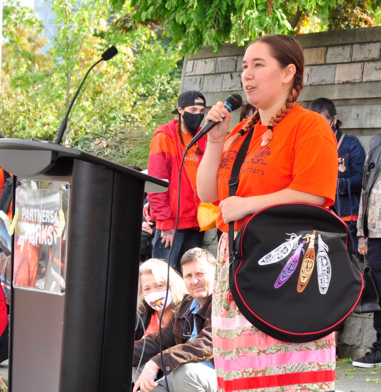 Kali Stierle, a board member of the SFU First Nations, Métis and Inuit Students Association, speaks at the Surrey ceremony