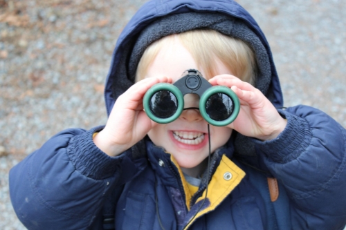 A child looking through binoculars