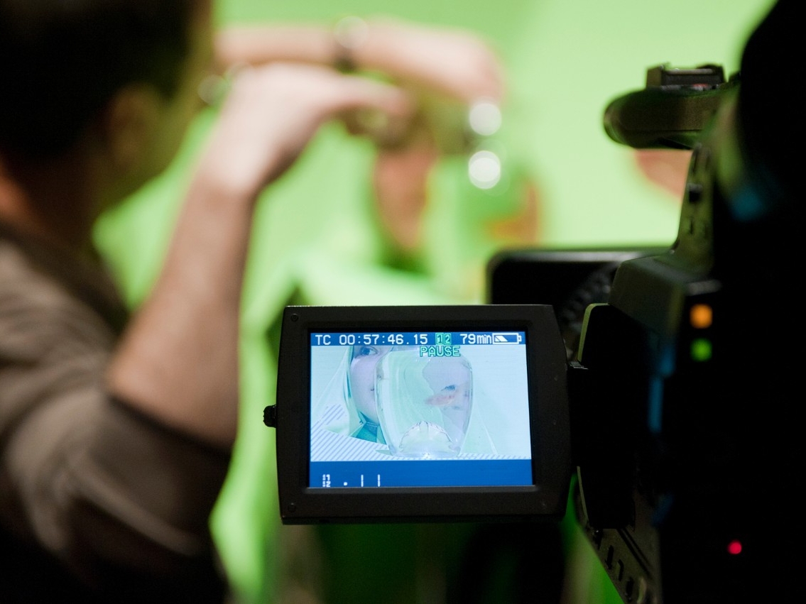 COPE Drama title written over a picture. The picture shows a LCD screen of video recording camera in focus with a blurred background of stage activity.