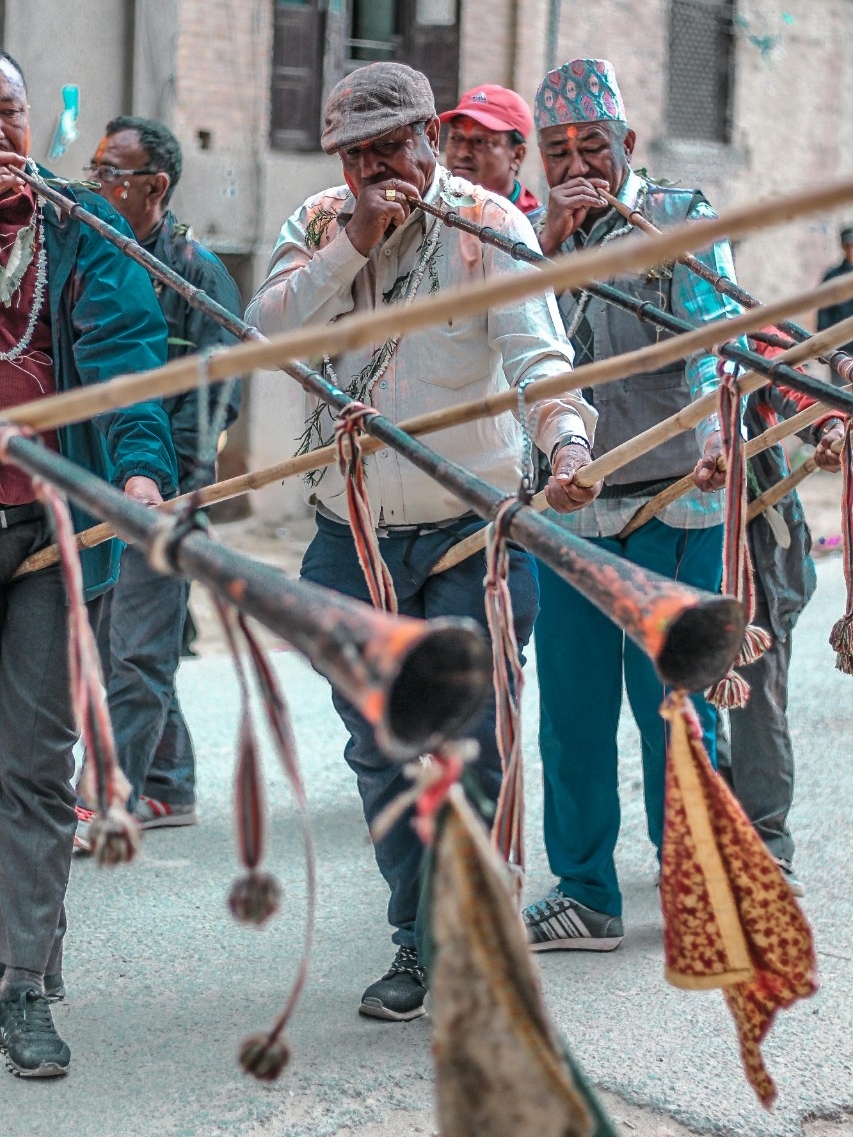 Group of older men blowing a trumpet in a performance