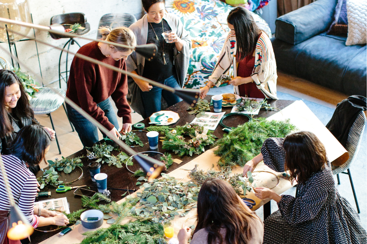 People making leaf wreaths at a table
