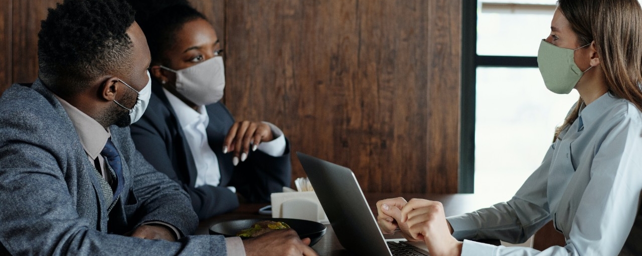 Three people in a meeting wearing face masks