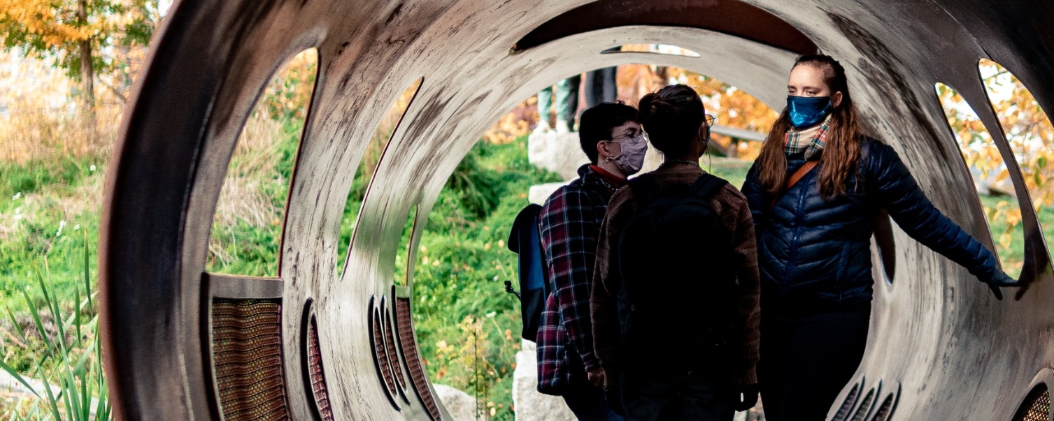 Three students standing in a tunnel art installation at SFU's Burnaby campus