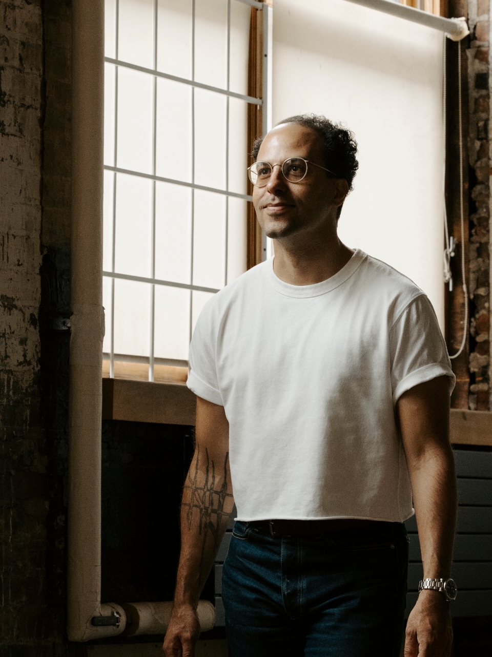 D.M. Bradford standing wearing a white t-shirt and jeans