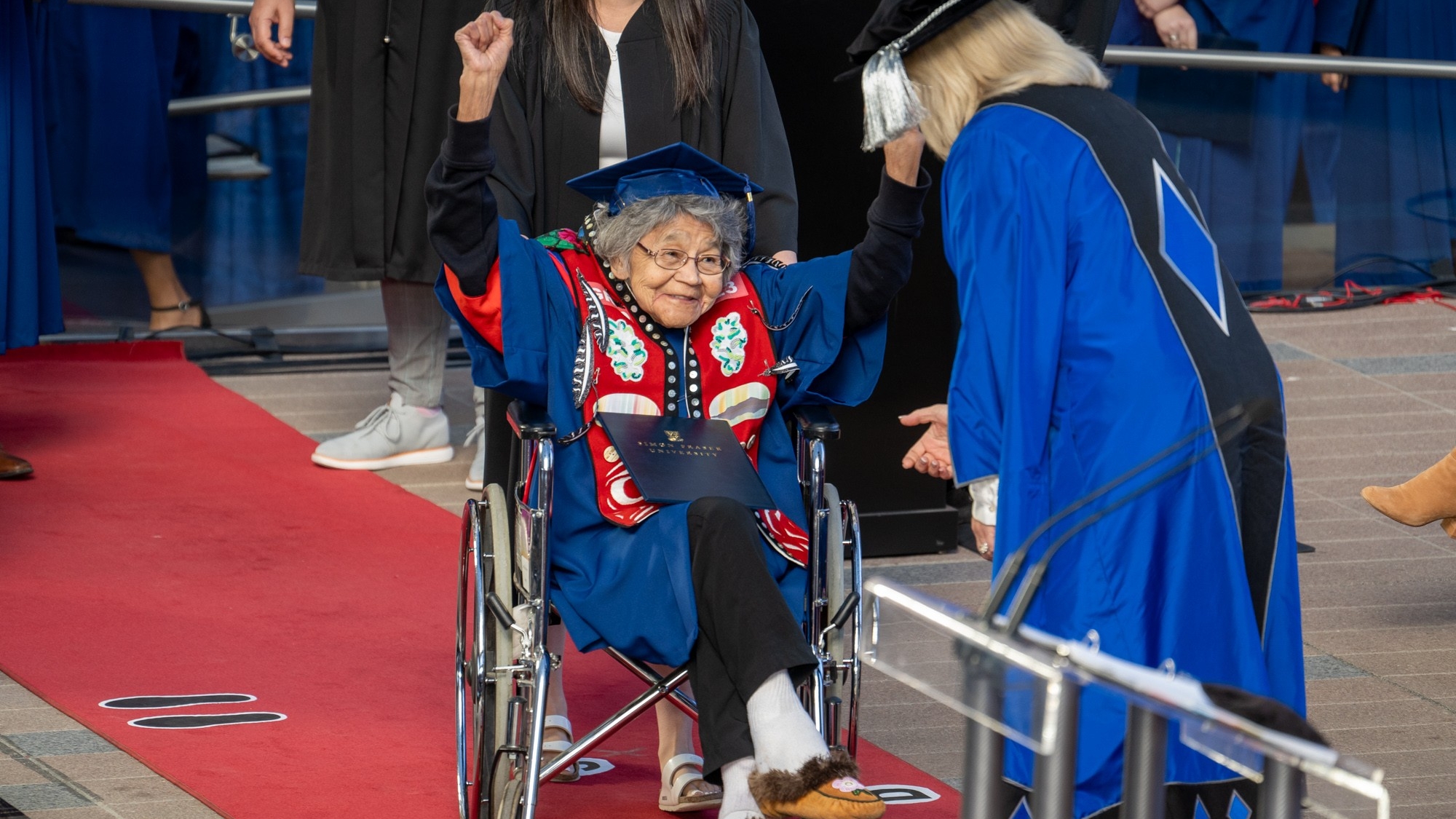 Bessie Cooley crossing the stage at Convocation receiving her MA.