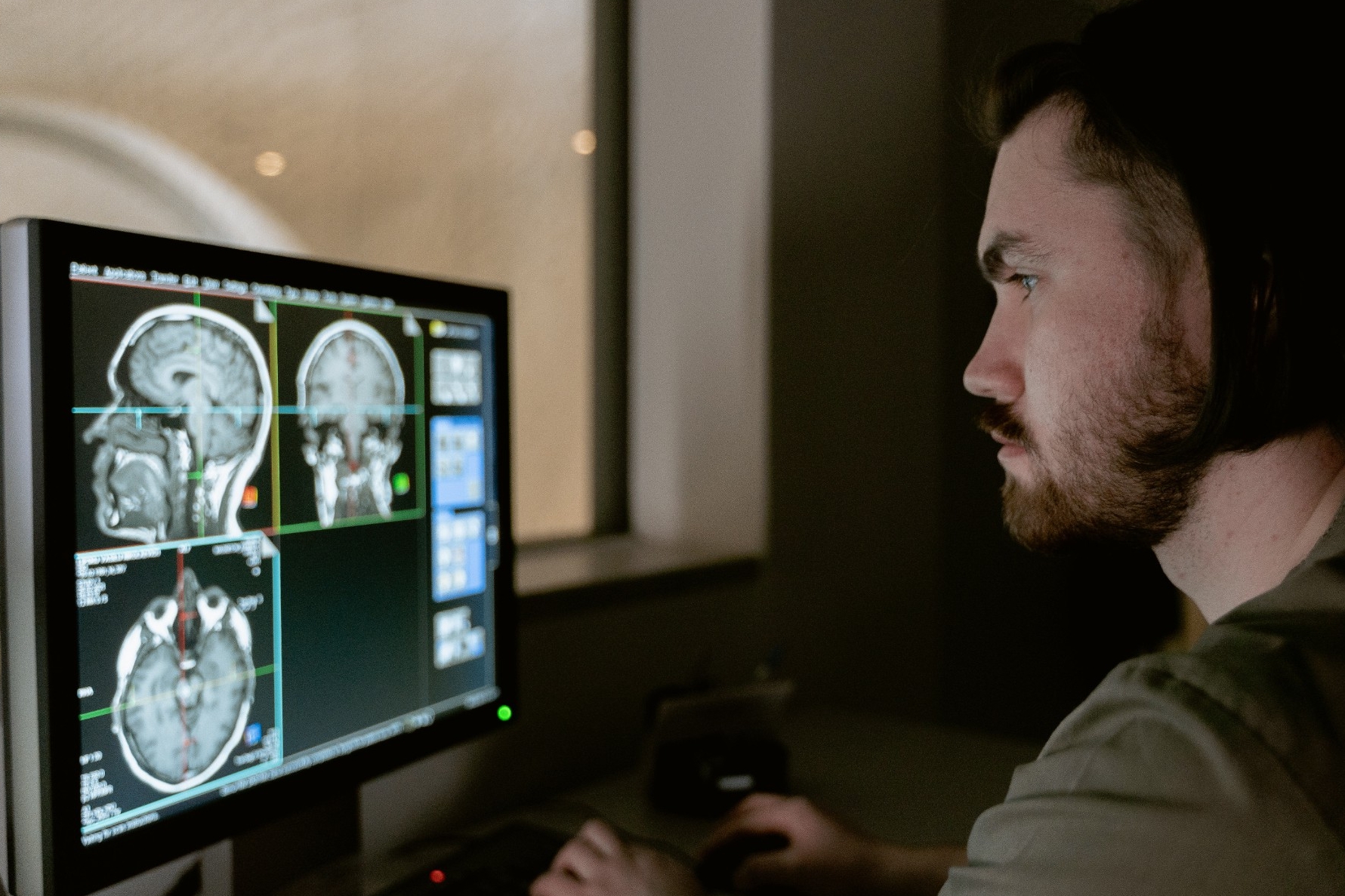 A researcher looks at slides of a brain on a computer.