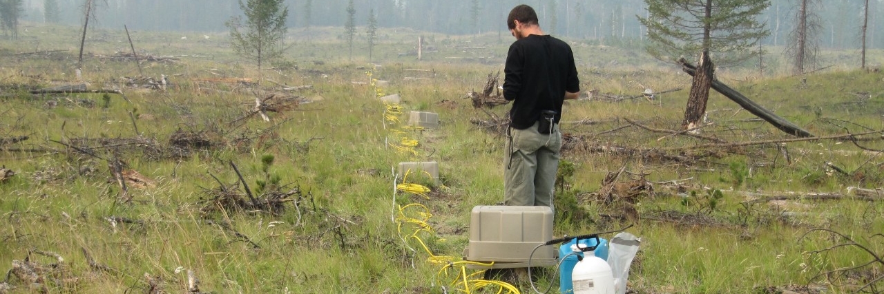 student using geophysical equipment in the field