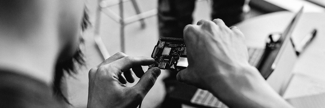 Man's hands working on a circuit board