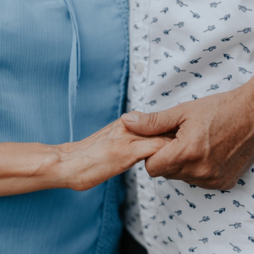 Older hand shaking a caregiver's hand