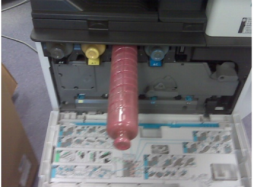 Inserting new toner bottle into the machine