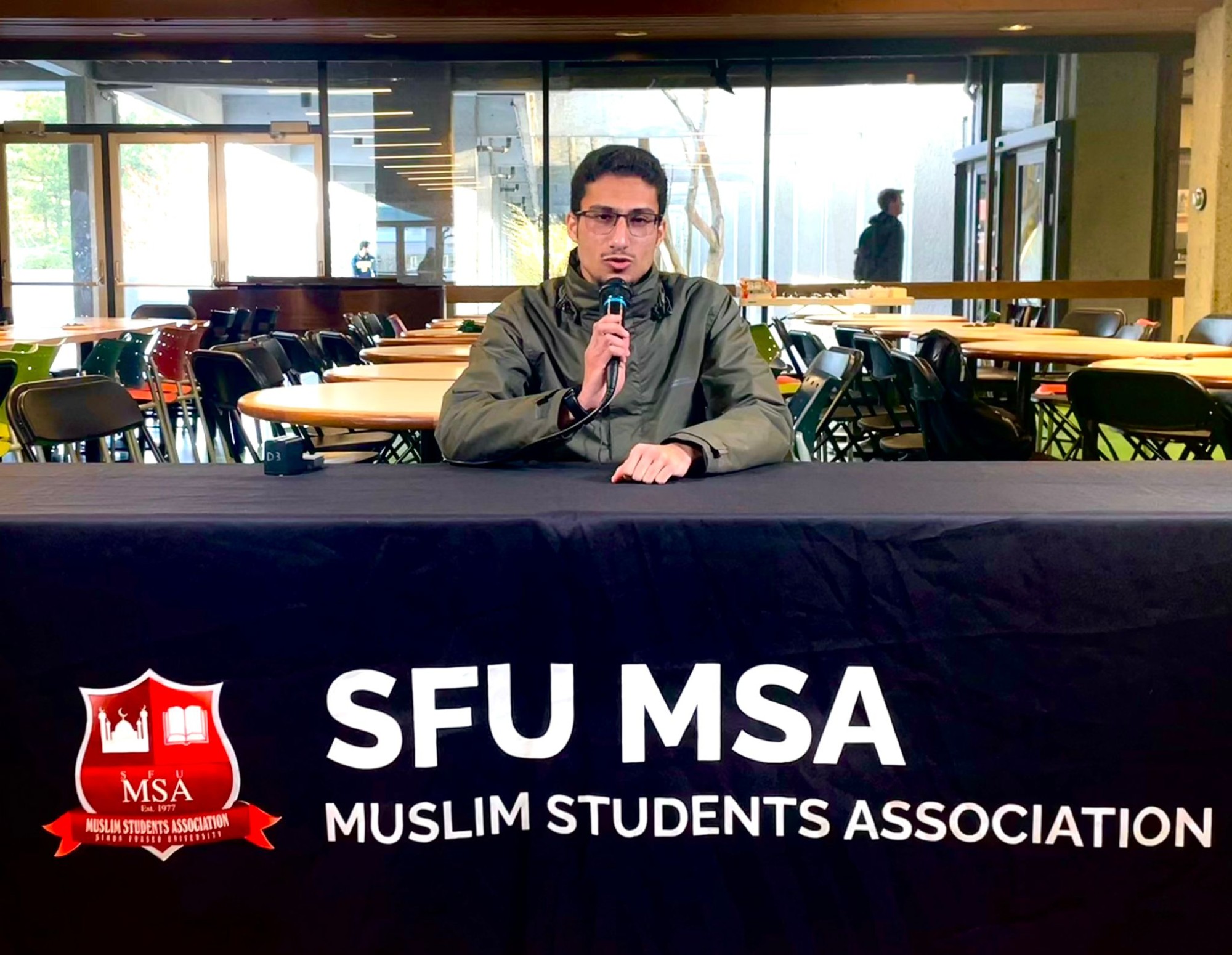 Esam Salahaldeen Abdullah Al-Mohamadi sitting at a table for the Muslim Students Association