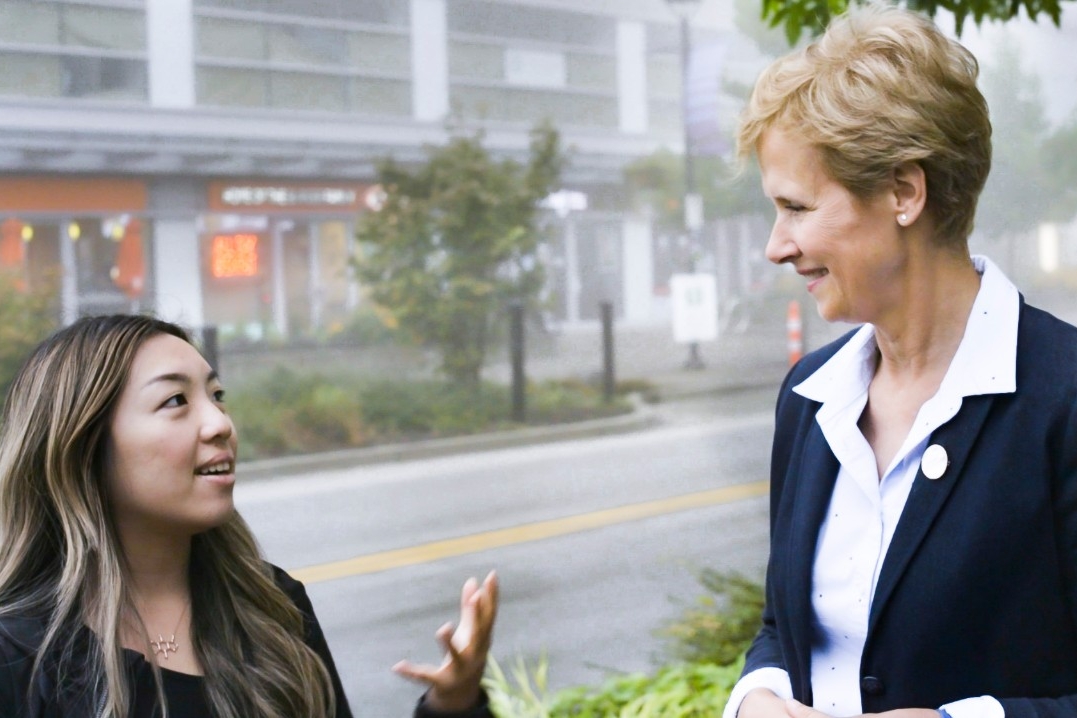 Photograph of Joy Johnson engaged in conversation with a young woman outdoors at the Burnaby Campus