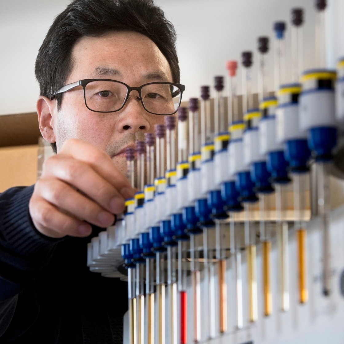 Nuclear Magenetic Resonance, man standing by row of test tubes