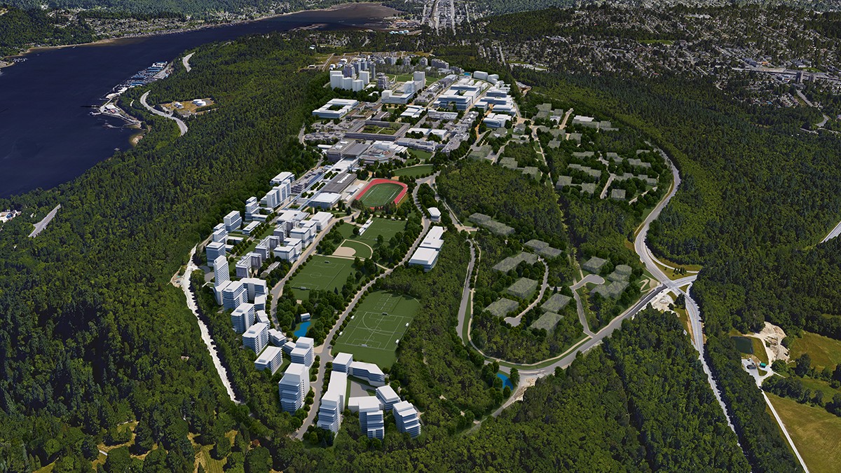 An overhead shot of the Burnaby campus - a series of grey buildings against the green backdrop of Burnaby mountain.