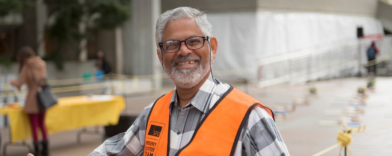 photo of man smiling wearing SFU volunteer jacket