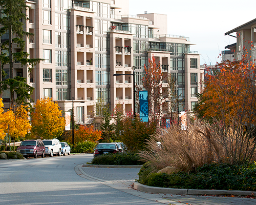 A residential road featuring apartment buildings and cars