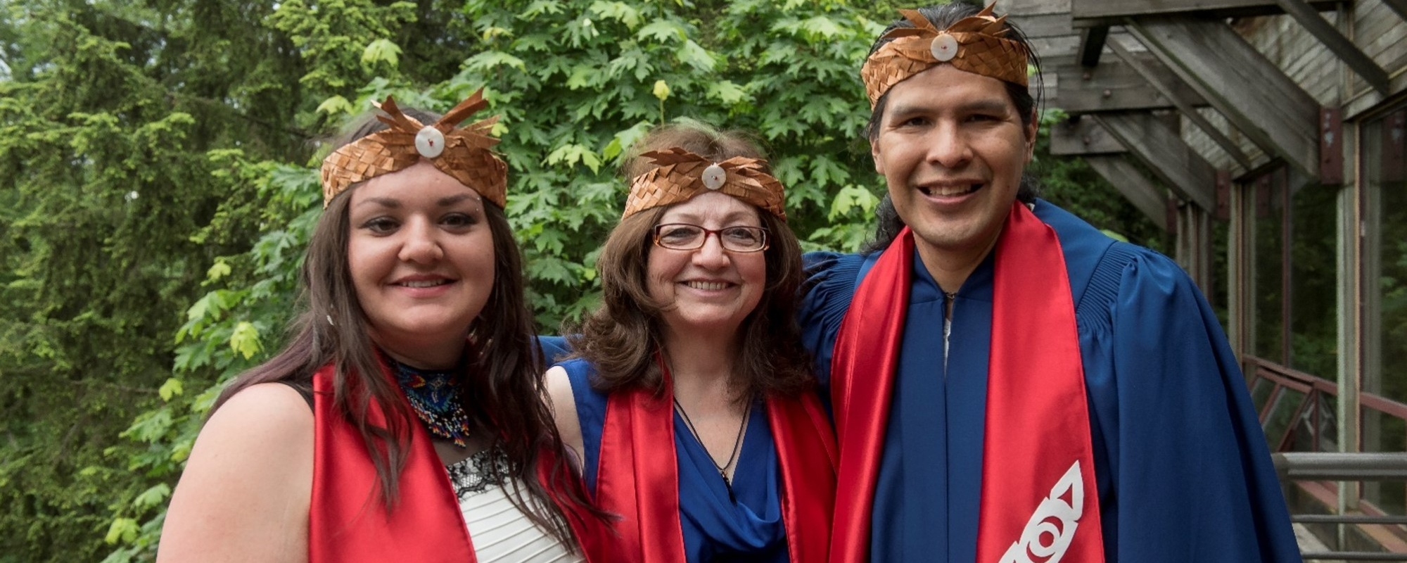 Three students in their convocation regalia