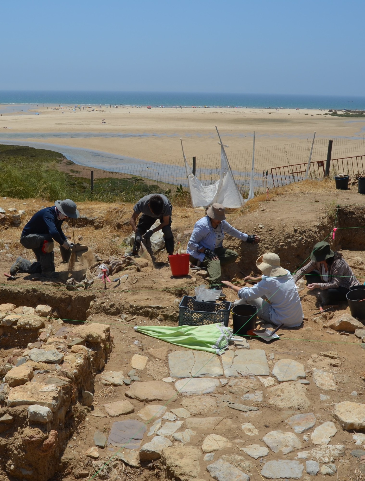 Cacale Velha village dig site with cobblestones, Algarve coast in the background