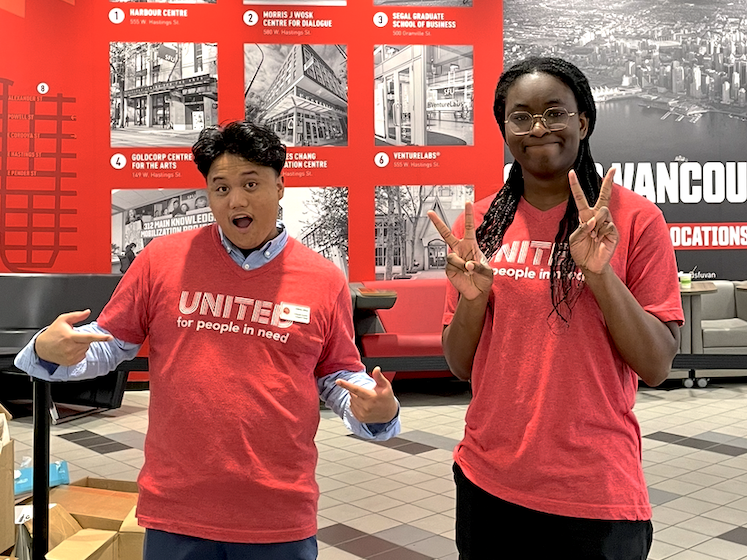 Two individuals posing with peace signs