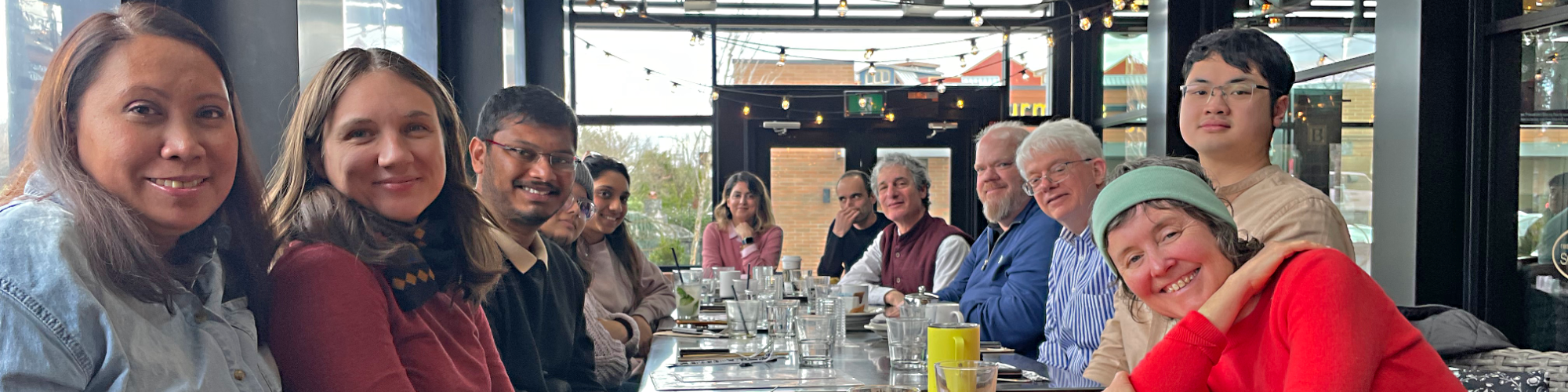 Photo of people sitting at a long table in a restaurant; header: USGSA