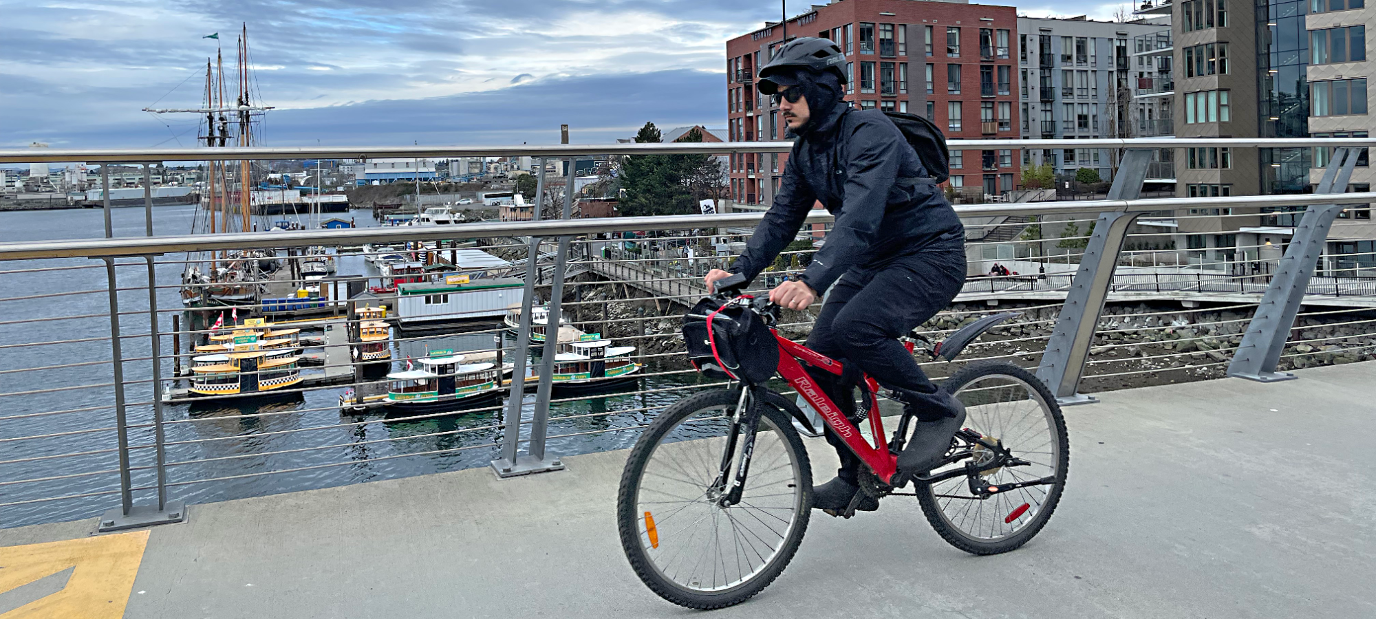 A man riding a bicycle across a bridge; Header: Research at SFU Urban Studies